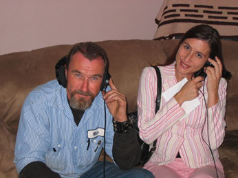 wade and kelly listening on headphones to sound piece on sofa